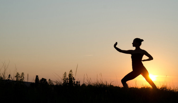 Donna che pratica esercizi di qi gong , taijiquan , ginnastica dolce e ginnastica posturale.