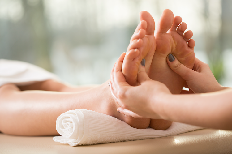 Massaggio di riflessologia plantare ai piedi.